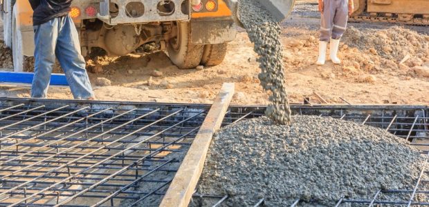 Concrete pouring during commercial concreting floors of buildings in construction site.